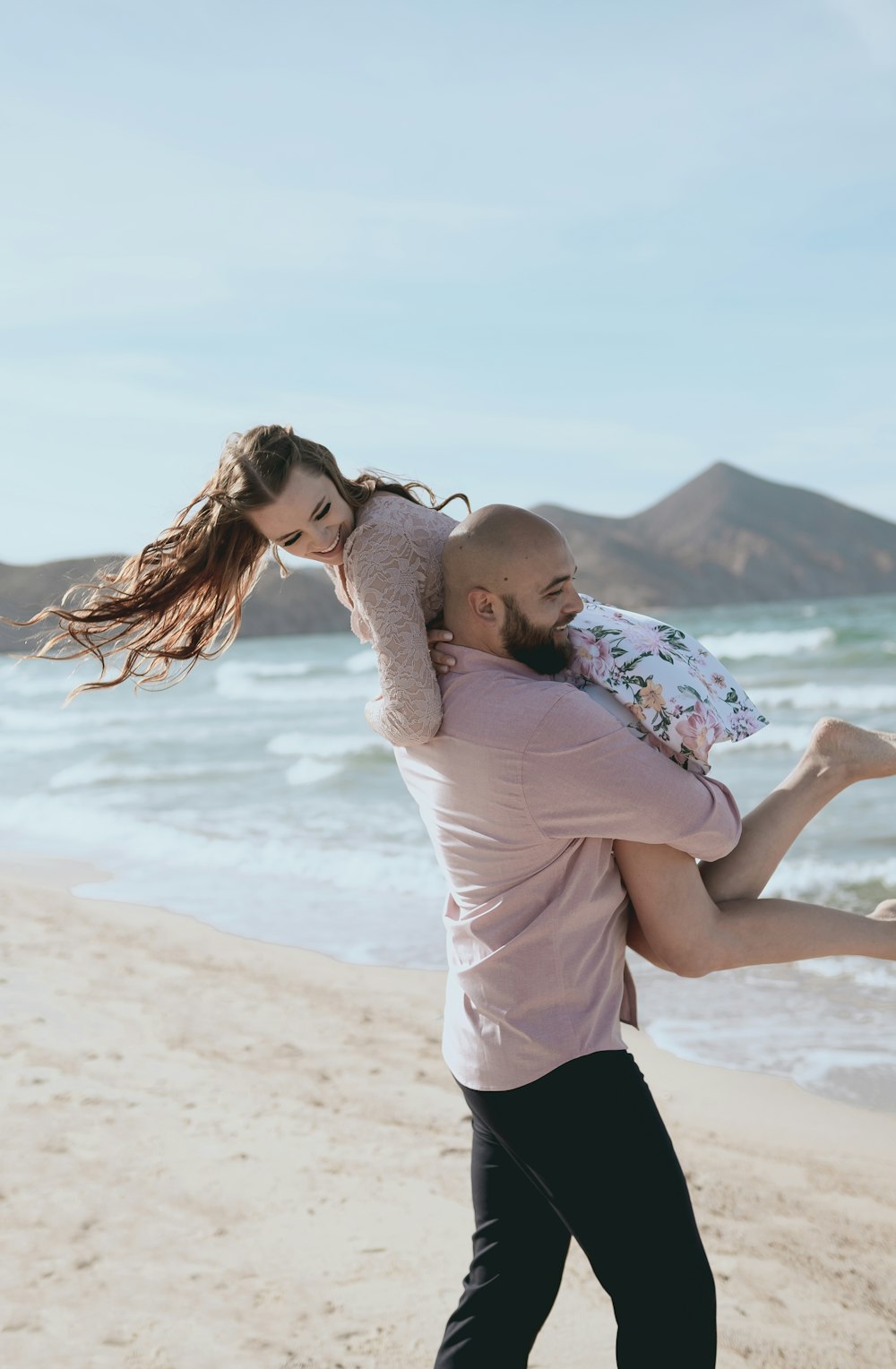 man and woman kissing on beach during daytime