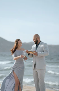 A smiling couple enjoying fresh seafood dishes at Gadus with the scenic Hamnøy harbor in the background.