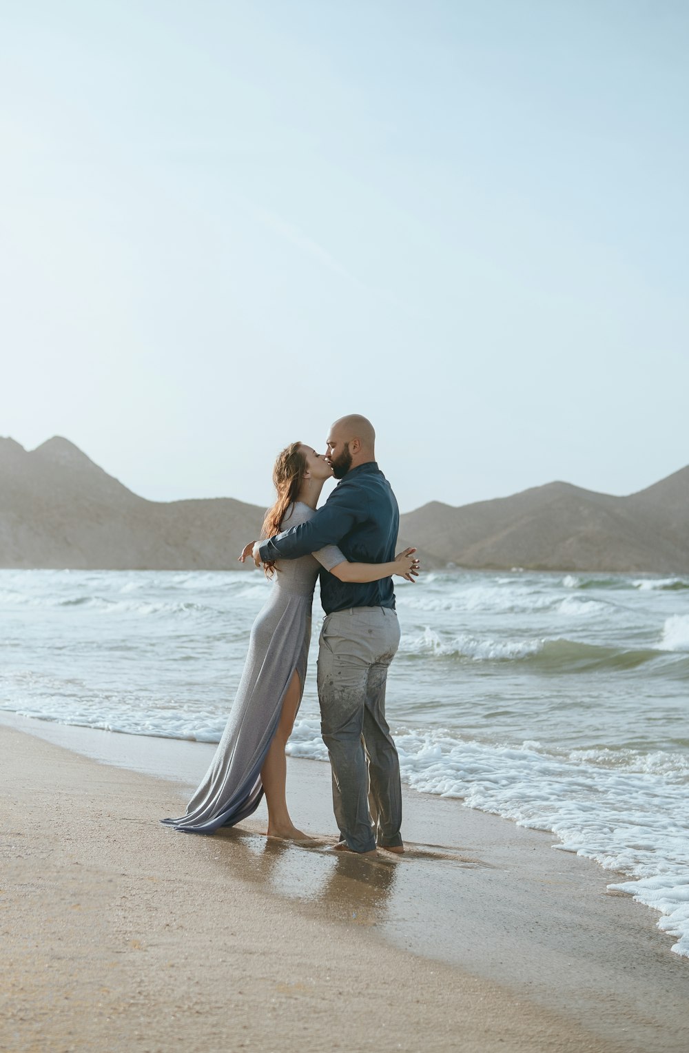 woman in black shirt and gray pants standing on beach during daytime