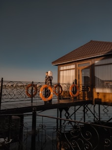 Couple exchanging vows on a lakeside deck at sunset with soft lighting.