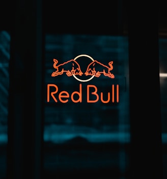 a red bull sign is lit up in the dark