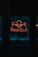 a red bull sign is lit up in the dark