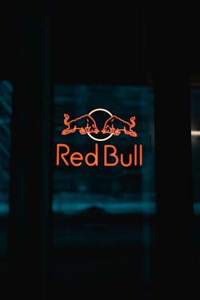 a red bull sign is lit up in the dark