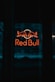 a red bull sign is lit up in the dark