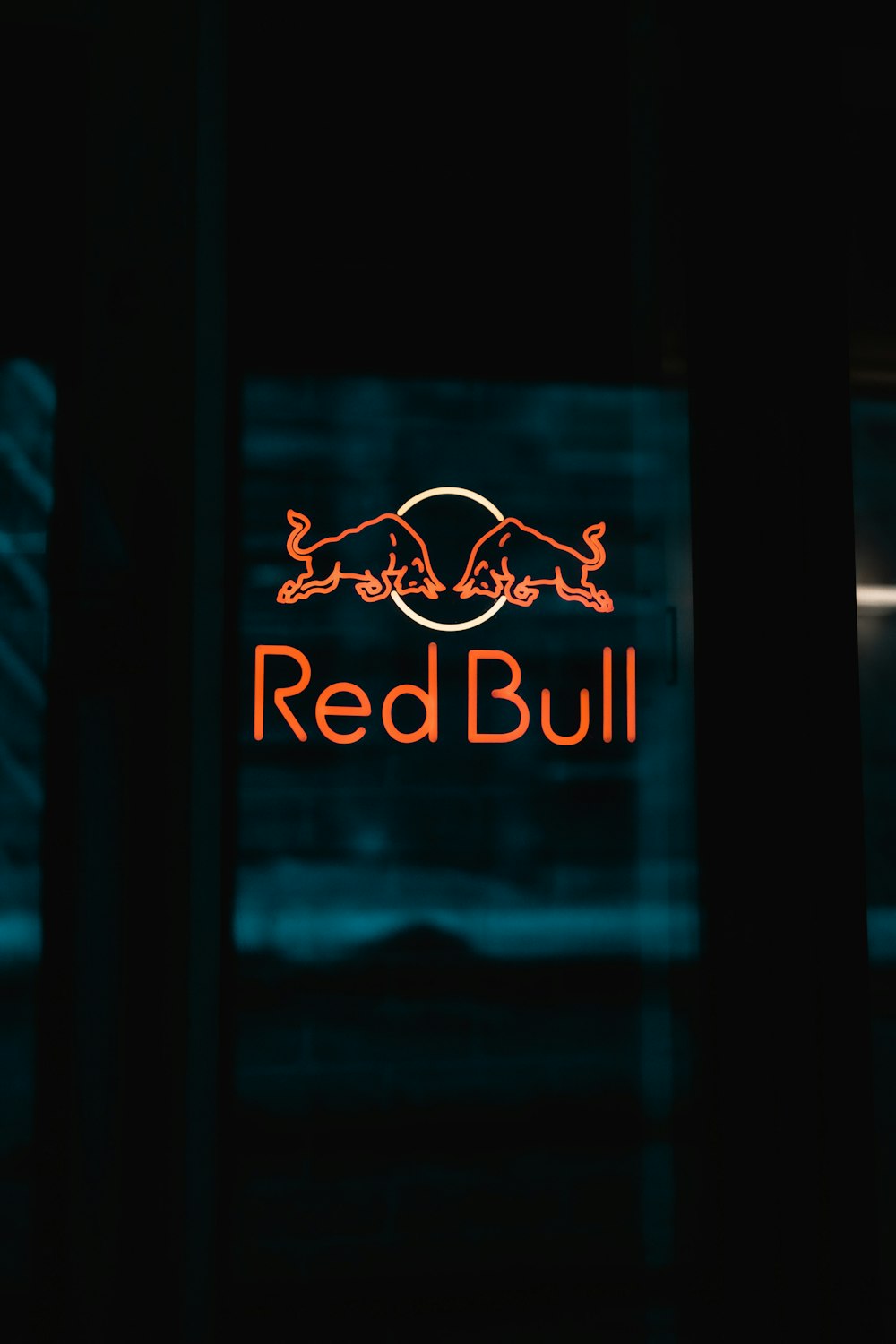 a red bull sign is lit up in the dark