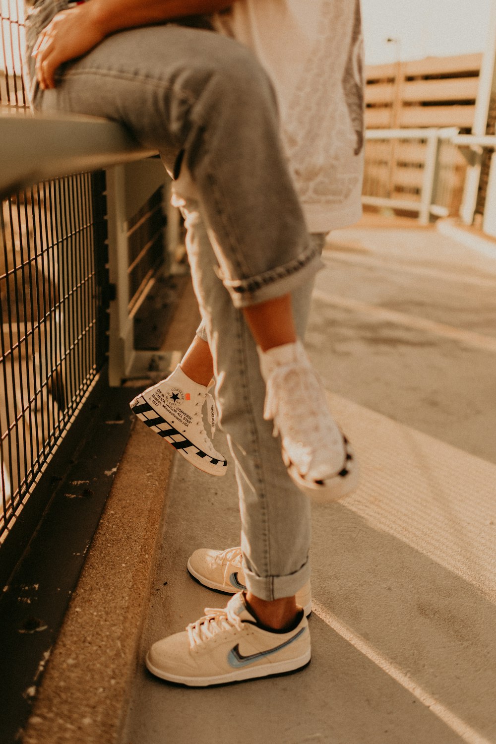 person in gray denim jeans and white converse all star high top sneakers