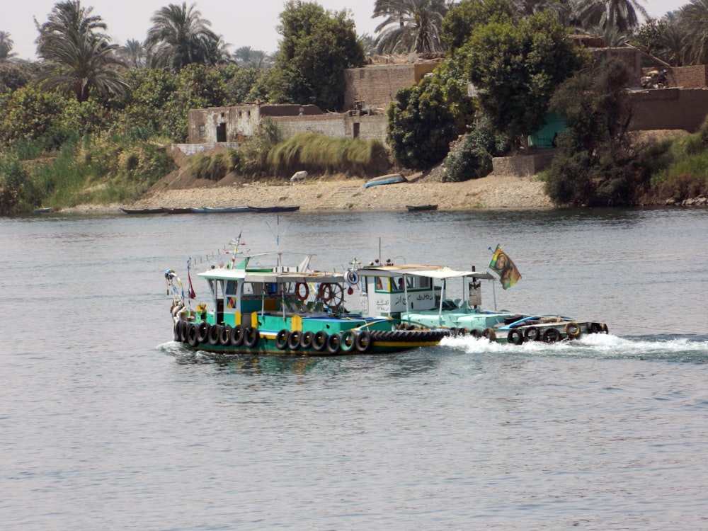 people riding on green boat on water during daytime