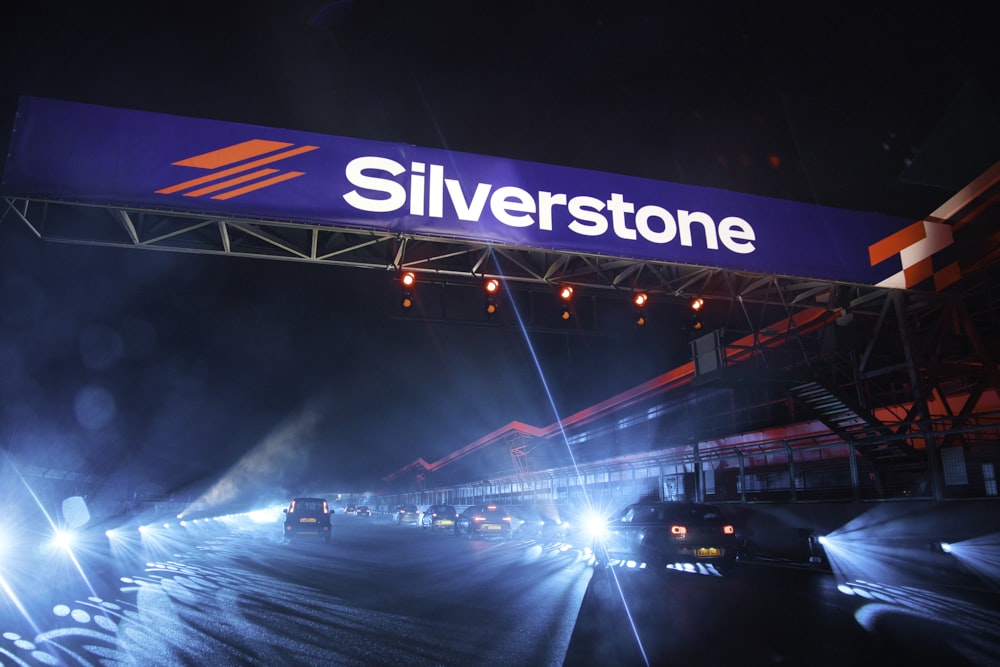 a silver stone sign above a highway at night