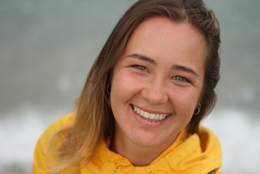 woman in yellow collared shirt smiling