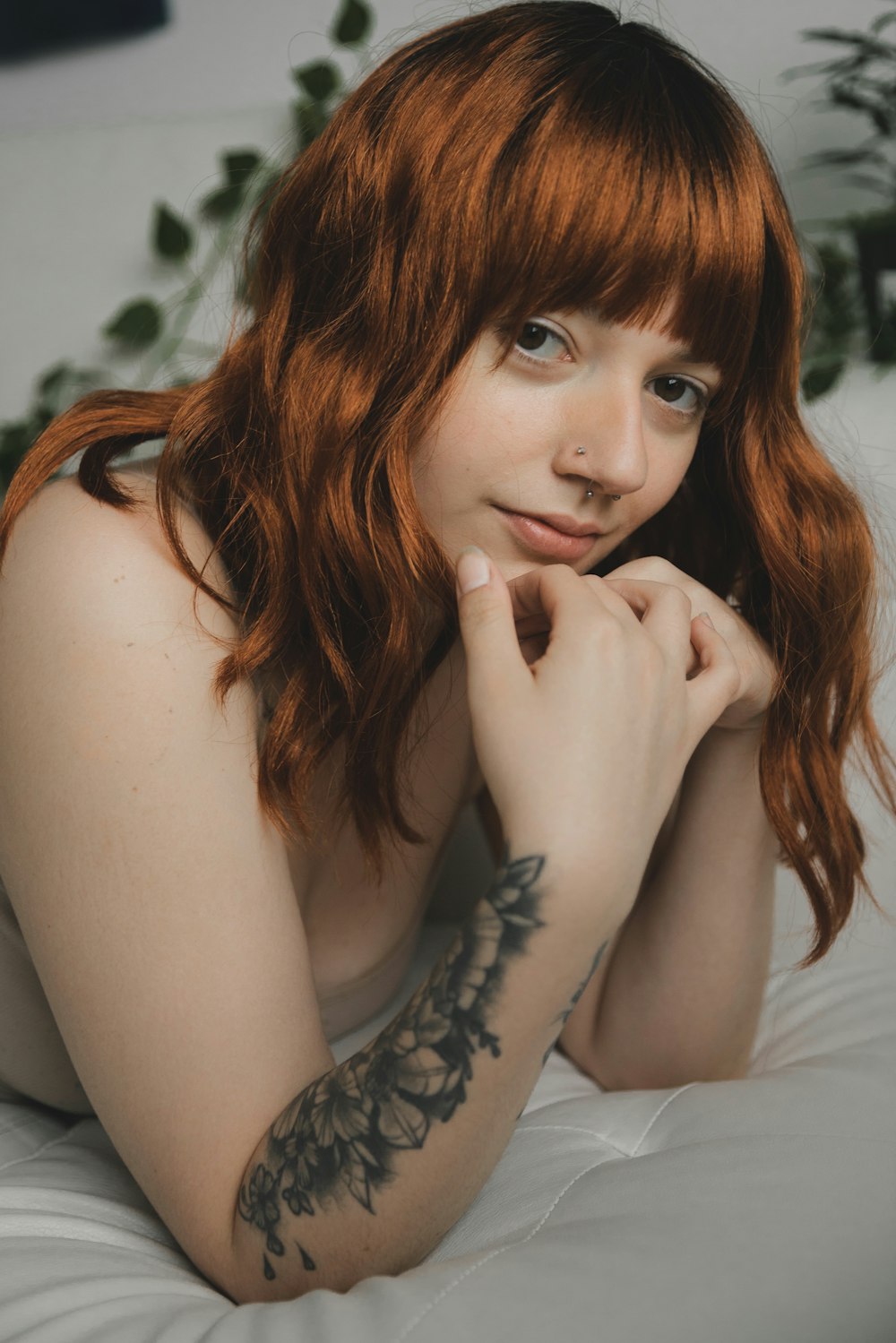 woman with red hair and black floral tattoo on her right hand