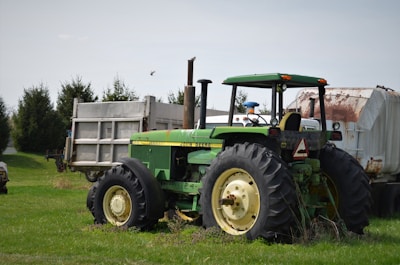 green tractor on green grass field during daytime