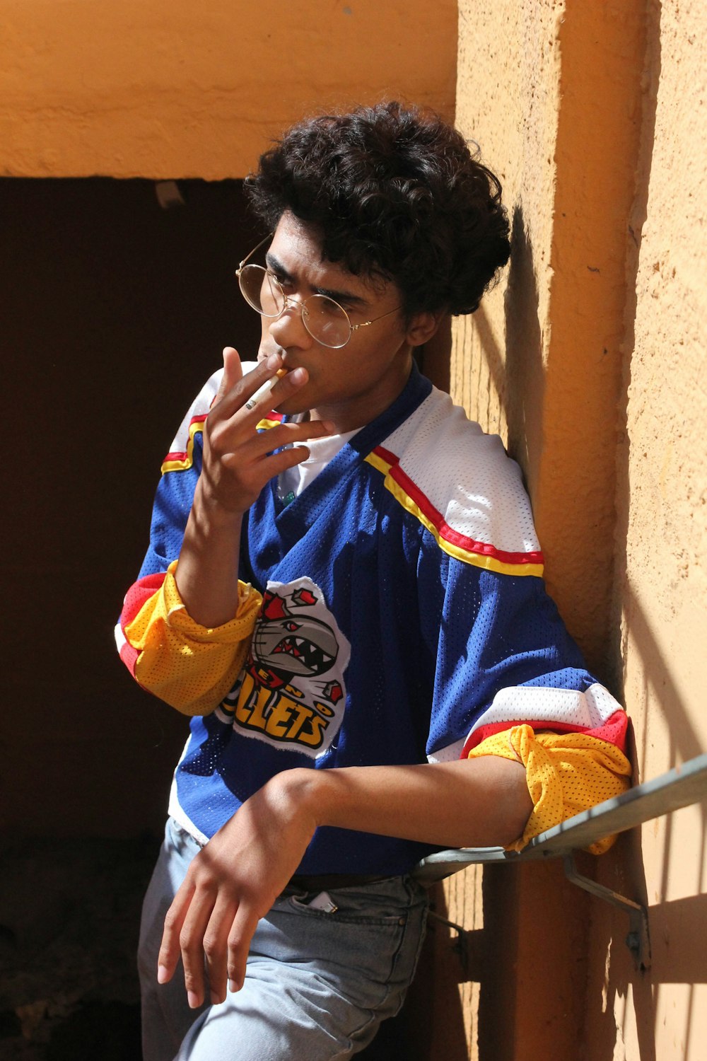 man in blue and white crew neck t-shirt smoking cigarette