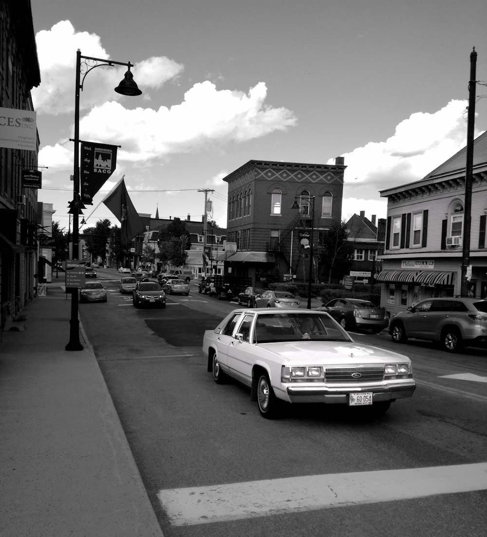 grayscale photo of pink car on road