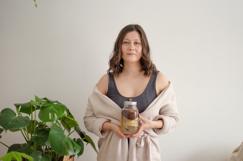 woman in pink dress holding glass jar