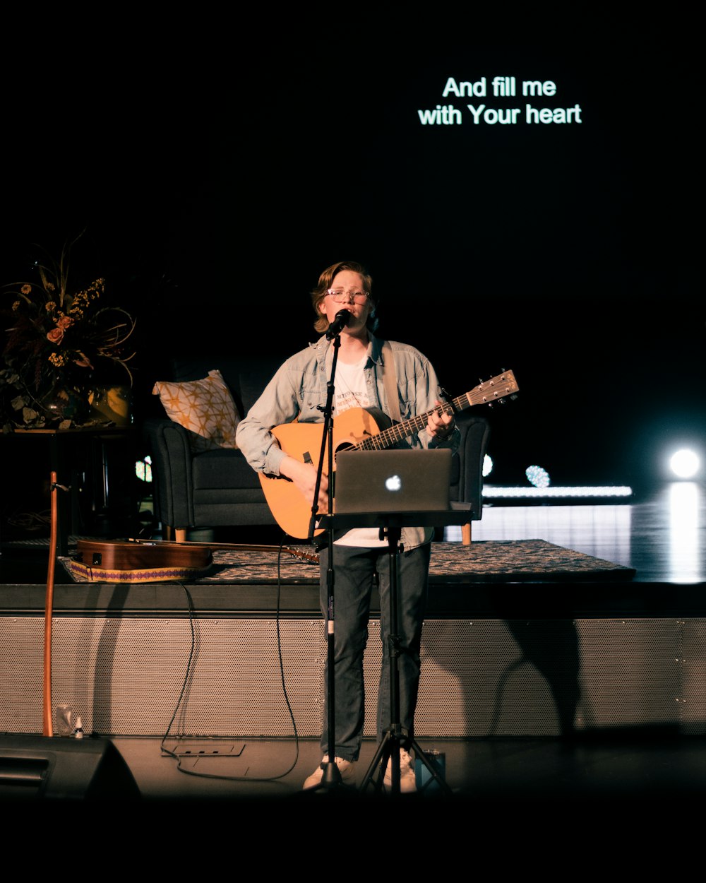 man in brown coat singing on stage