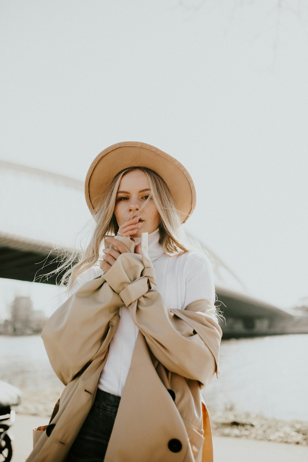 woman in brown sun hat and white coat