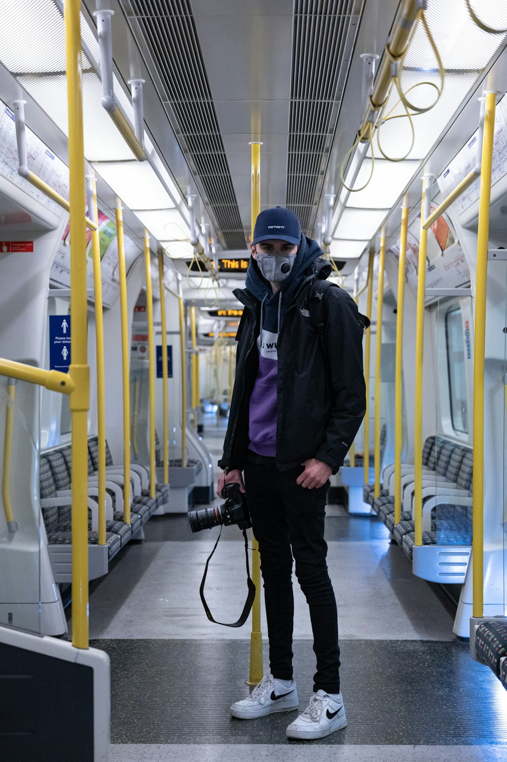 hombre con chaqueta negra con casco azul de pie en la estación de tren