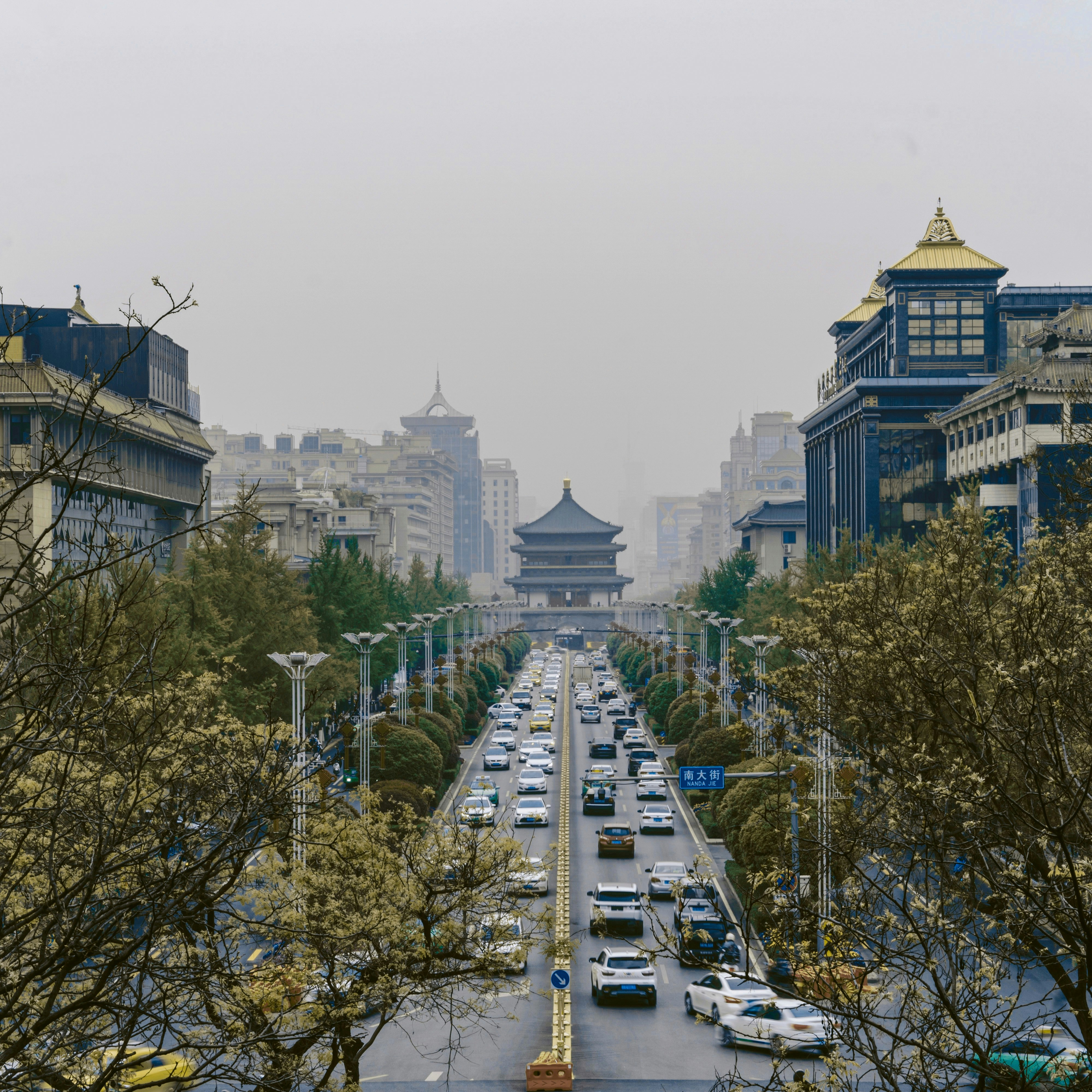 cars parked on parking lot near high rise buildings during daytime