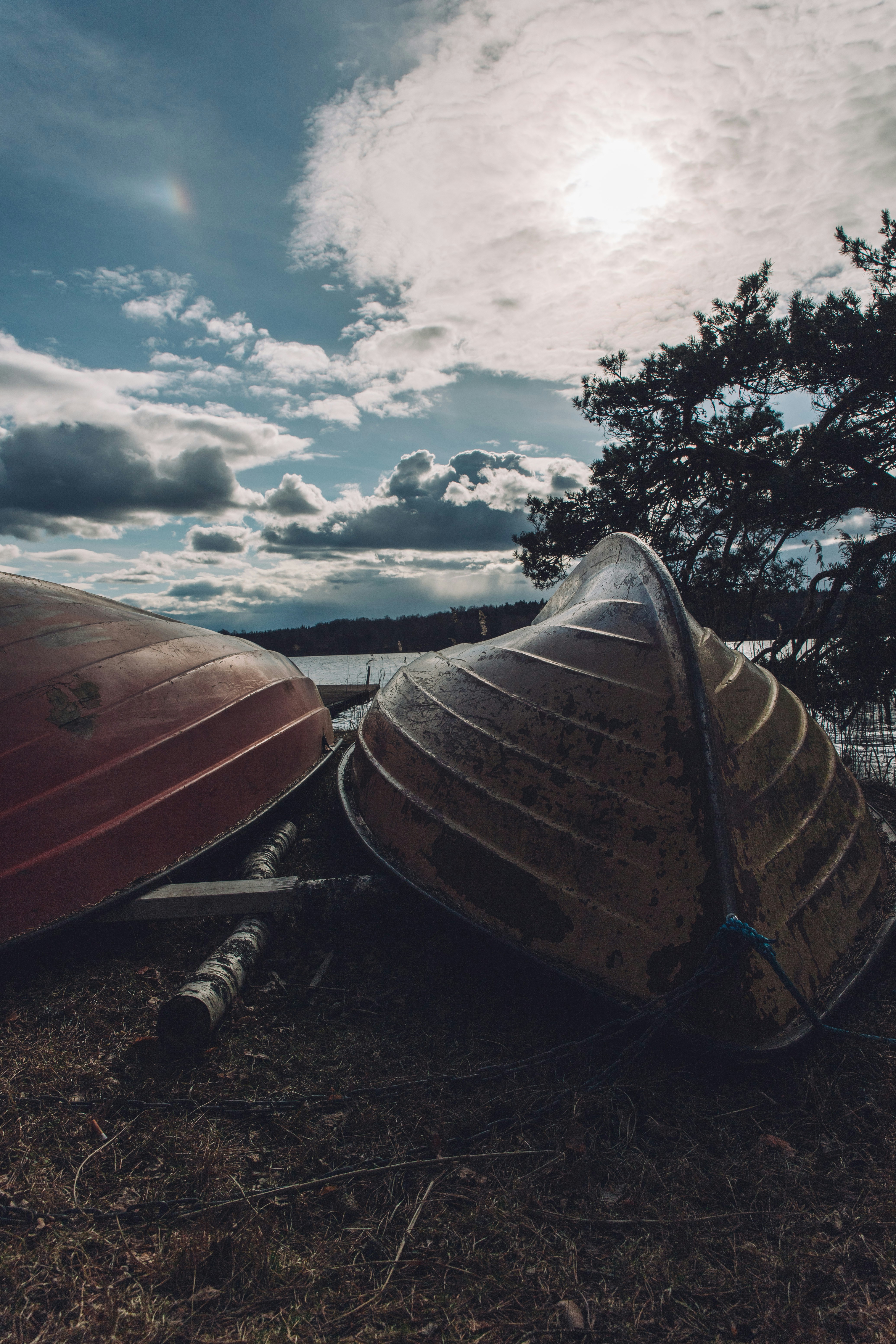 낮 동안 수역 근처의 갈색 모래 위에서 갈색 카누