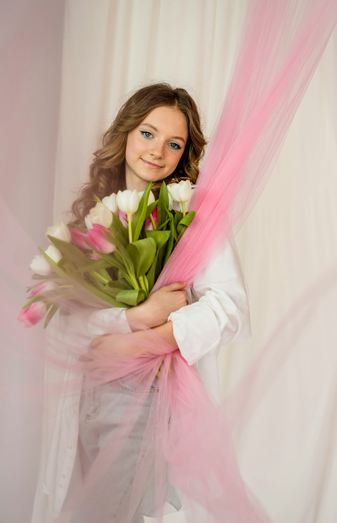 woman in white long sleeve shirt holding bouquet of flowers