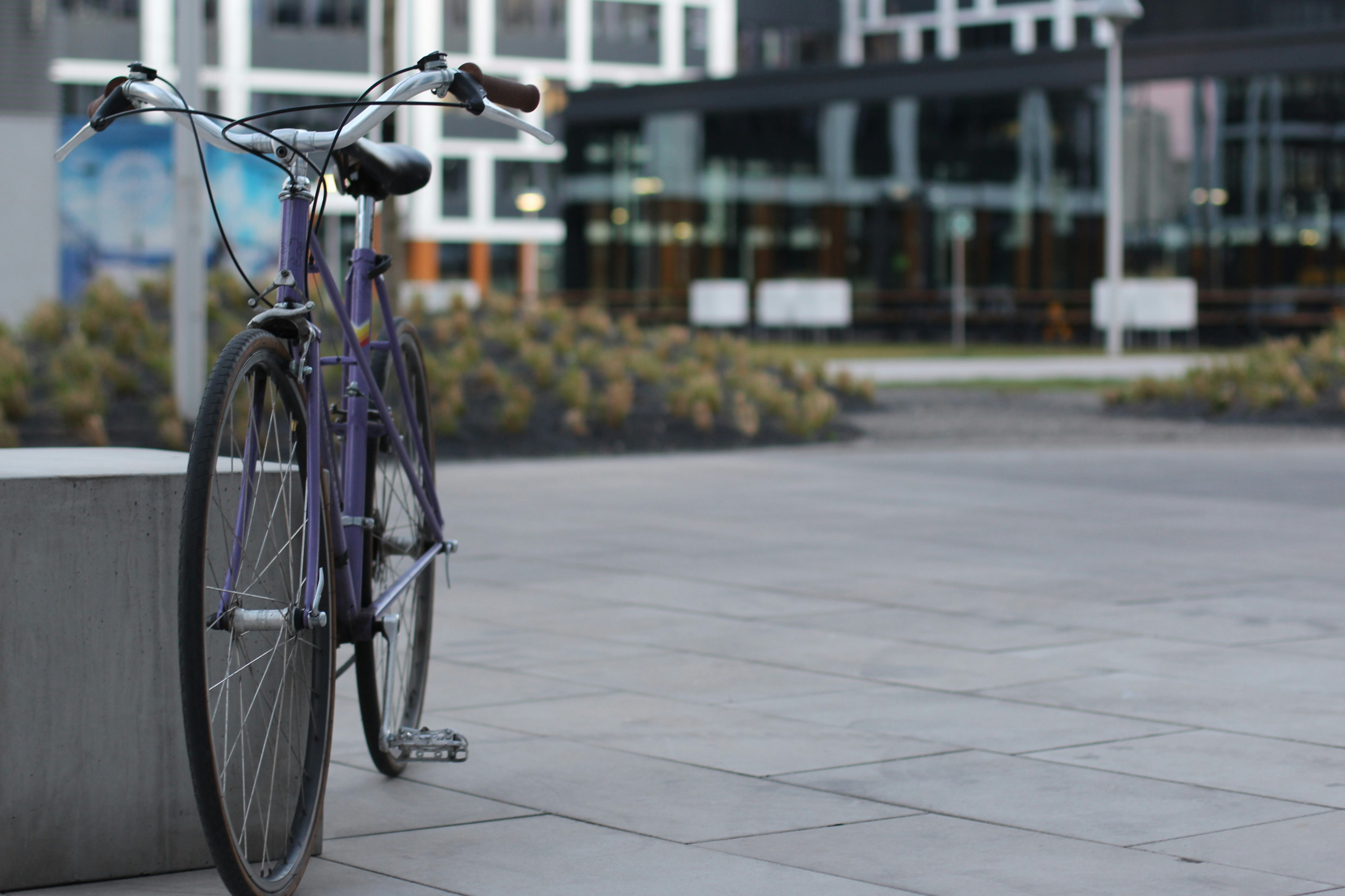 blue city bike on gray concrete pavement during daytime
