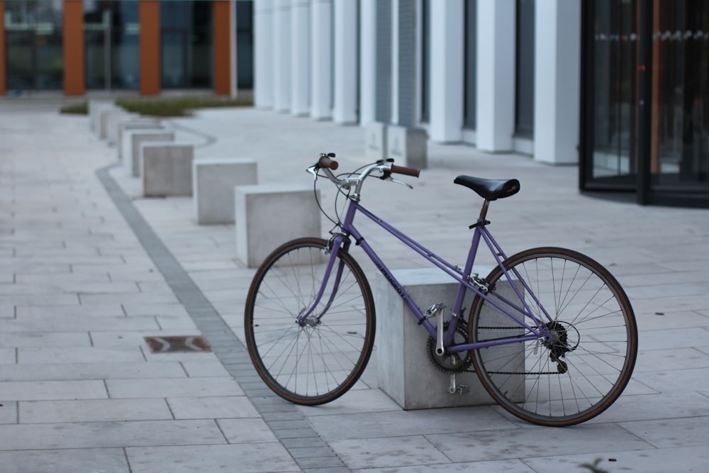blue city bike parked on sidewalk during daytime