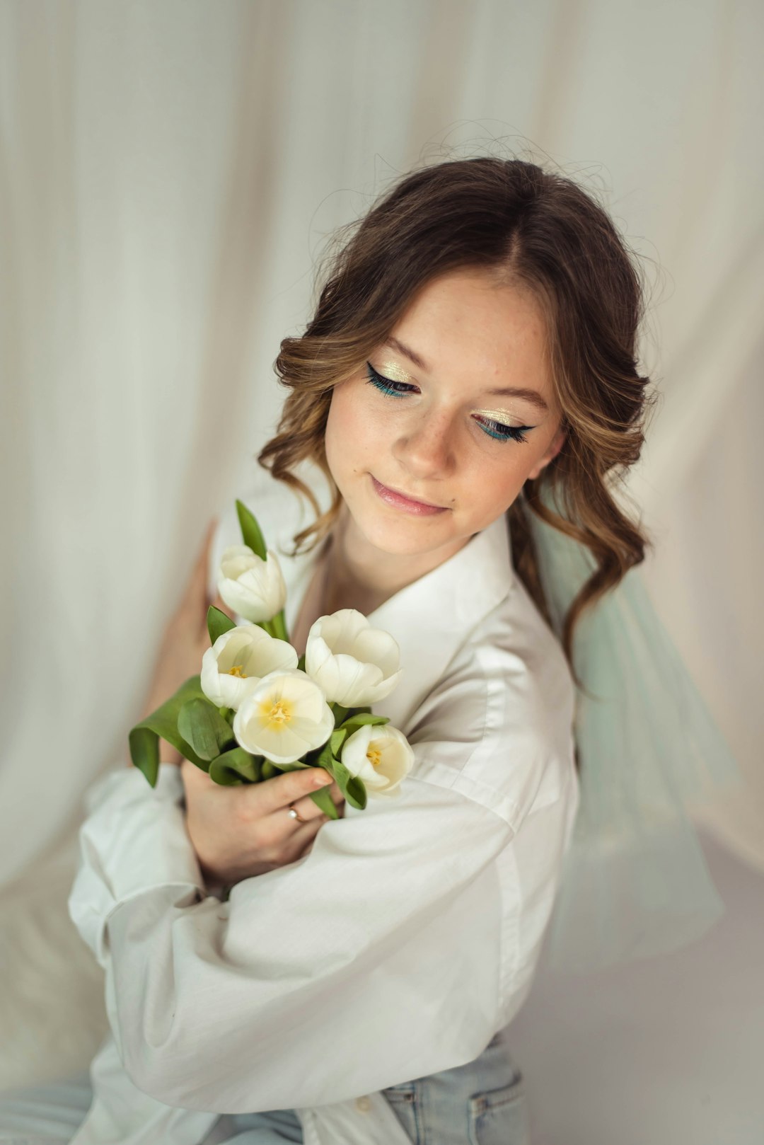 woman in white dress shirt holding white flower