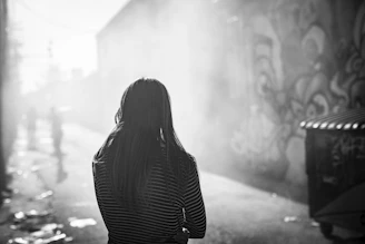 Black and white photo of Dash Caine 040 walking through a misty urban alley at dawn.