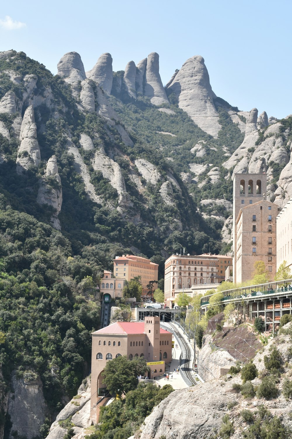 Edificio de hormigón marrón cerca de árboles verdes y montaña durante el día