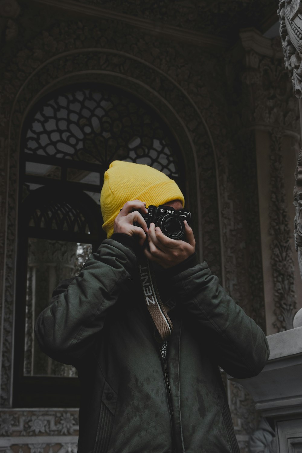 man in black leather jacket wearing yellow knit cap and black sunglasses