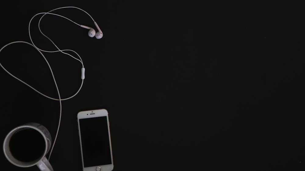 white samsung android smartphone with white earbuds