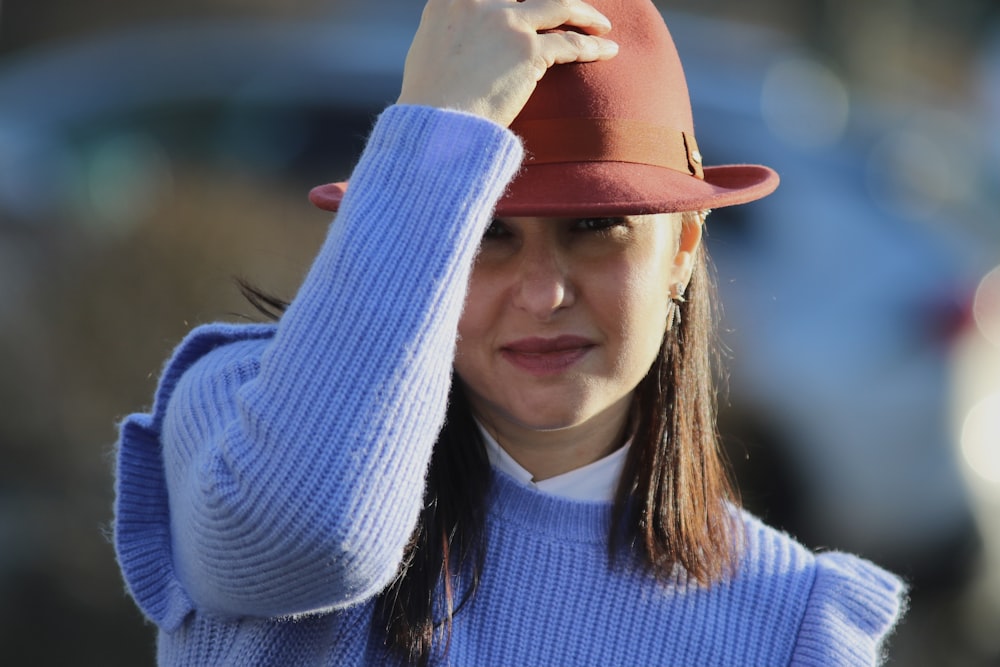 a woman wearing a blue sweater and a red hat