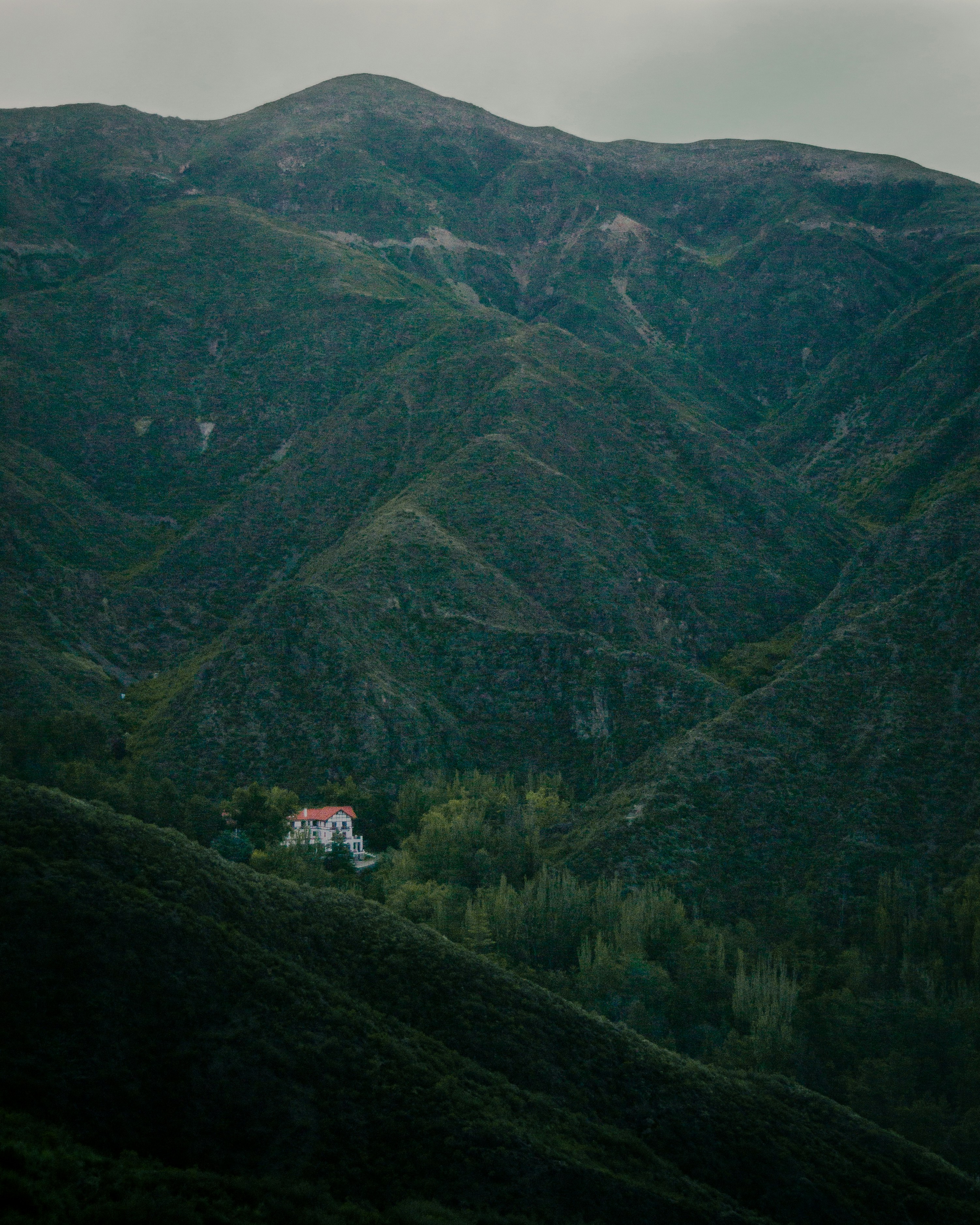Montañas verdes bajo el cielo blanco durante el día