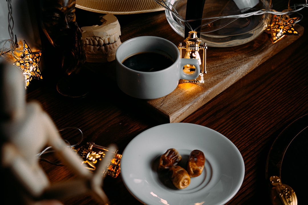 chocolate cookies on white ceramic plate beside white ceramic mug on brown wooden table