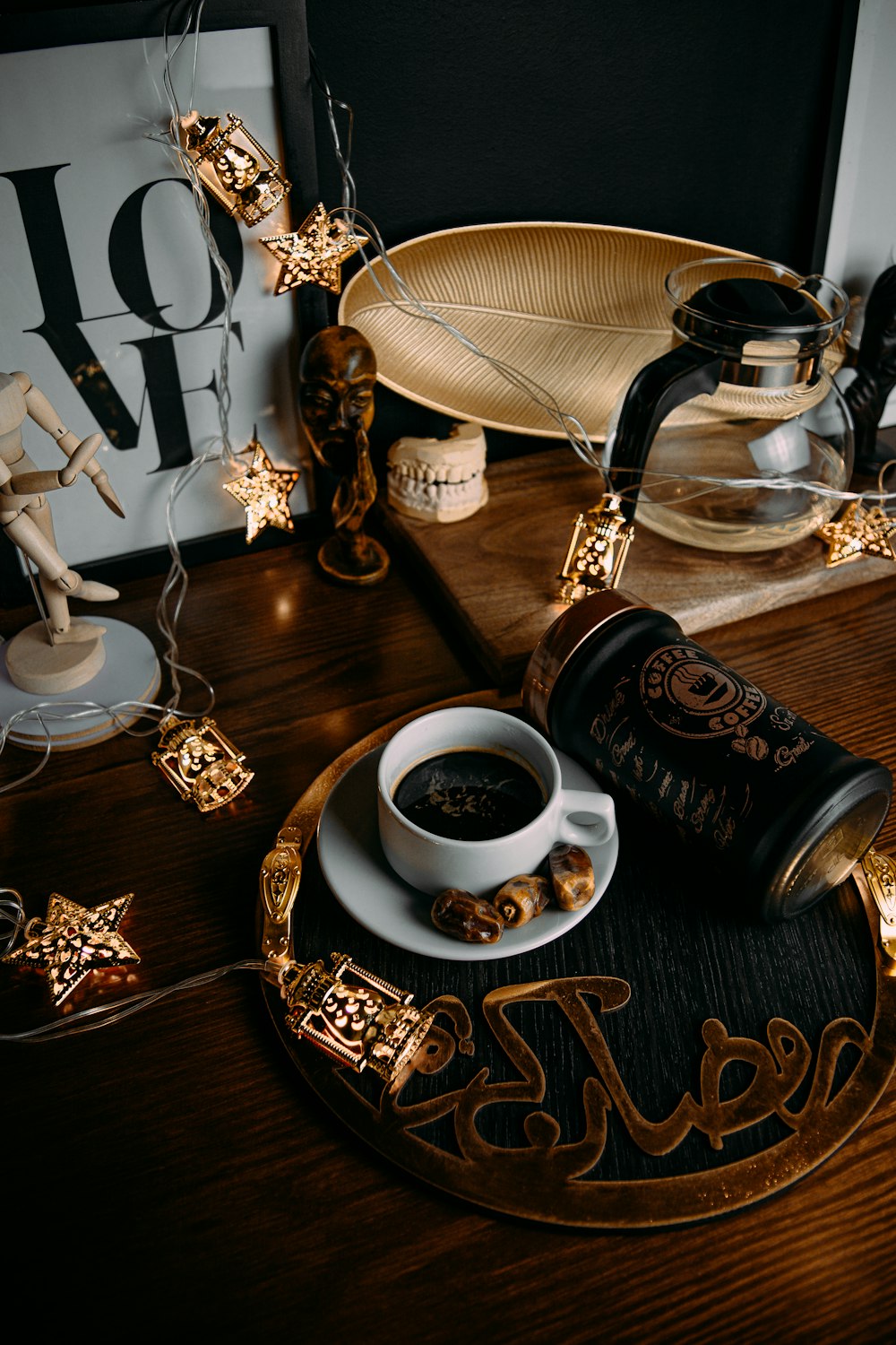 black ceramic mug on saucer beside stainless steel spoon