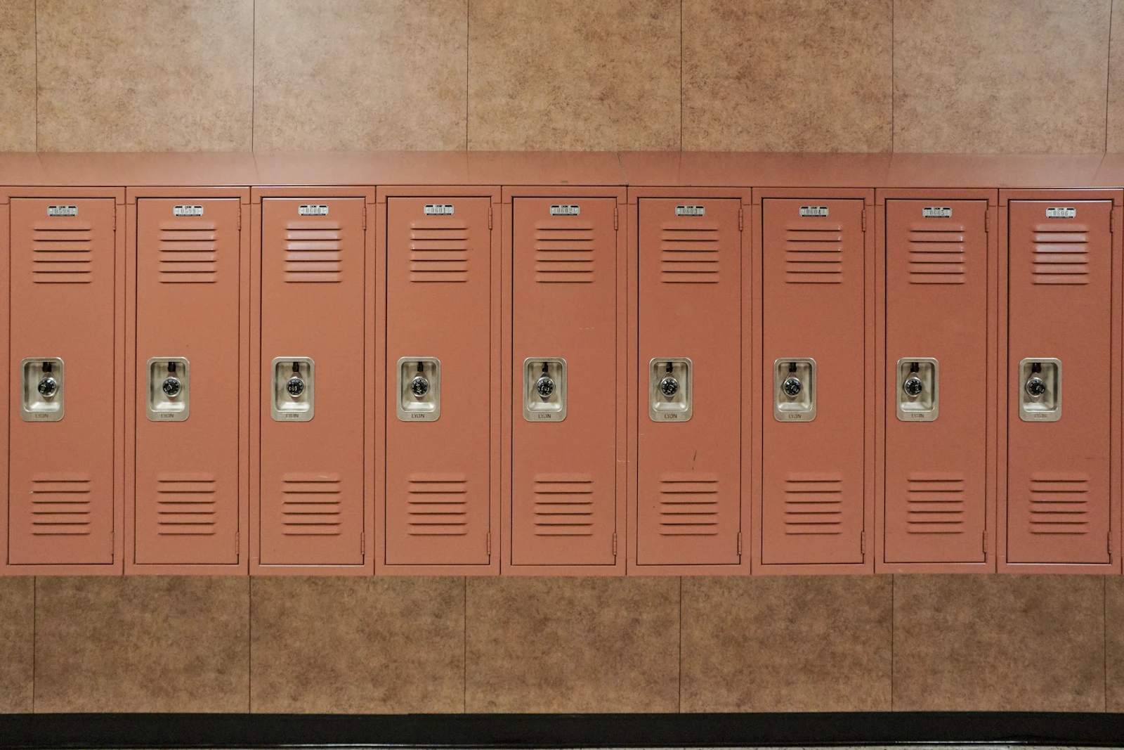 School lockers lined up along the wall of a high school hallway