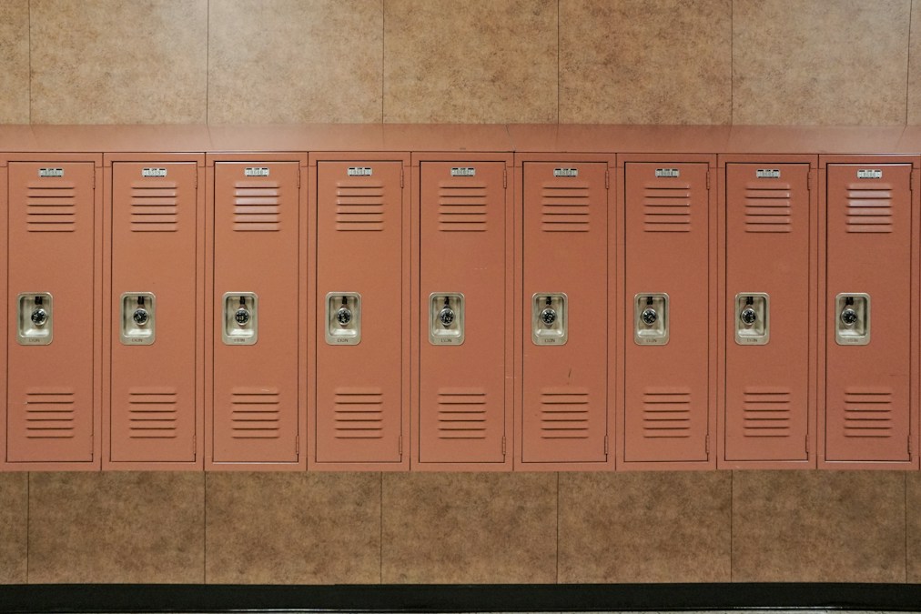 Rangée de casiers métalliques rouges dans un couloir de lycée (photo d’illustration)