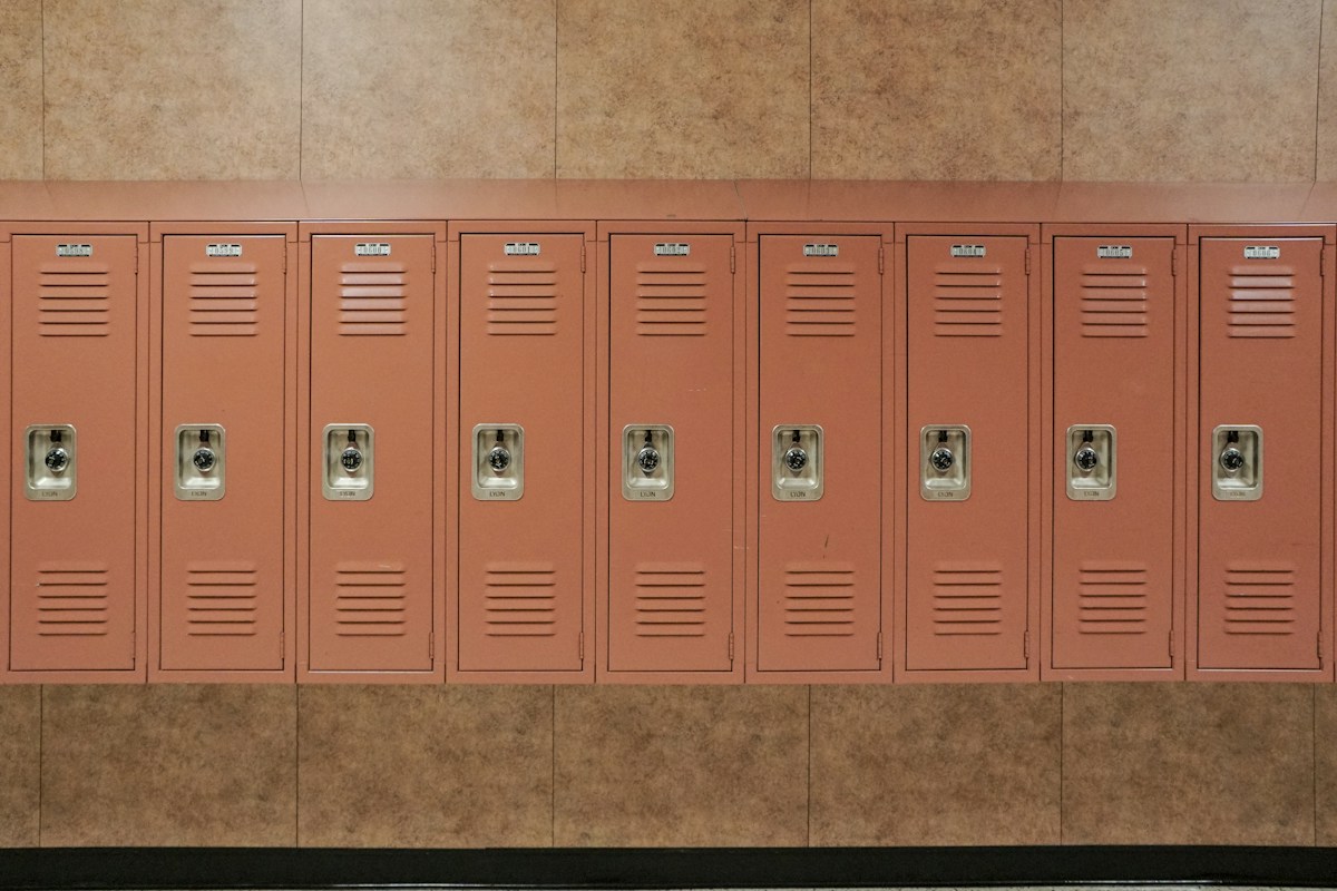 Red metal locker against a backdrop of green ceramic tiles, illustrating classroom organization for teachers.