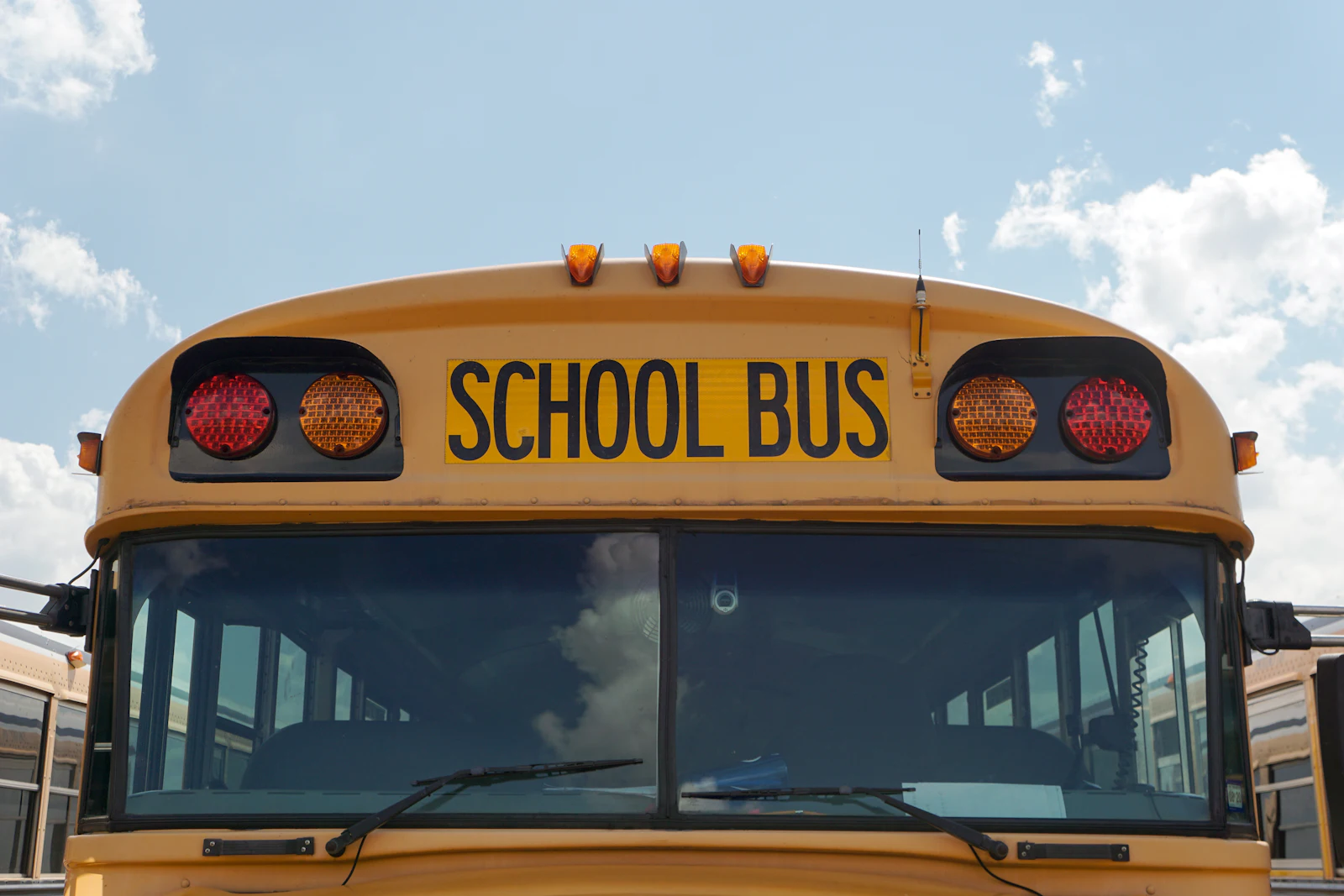 photo — driver doing a pre-trip walkaround inspection of a yellow school bus
