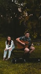 woman in black and white floral shirt sitting on brown wooden bench beside woman in white