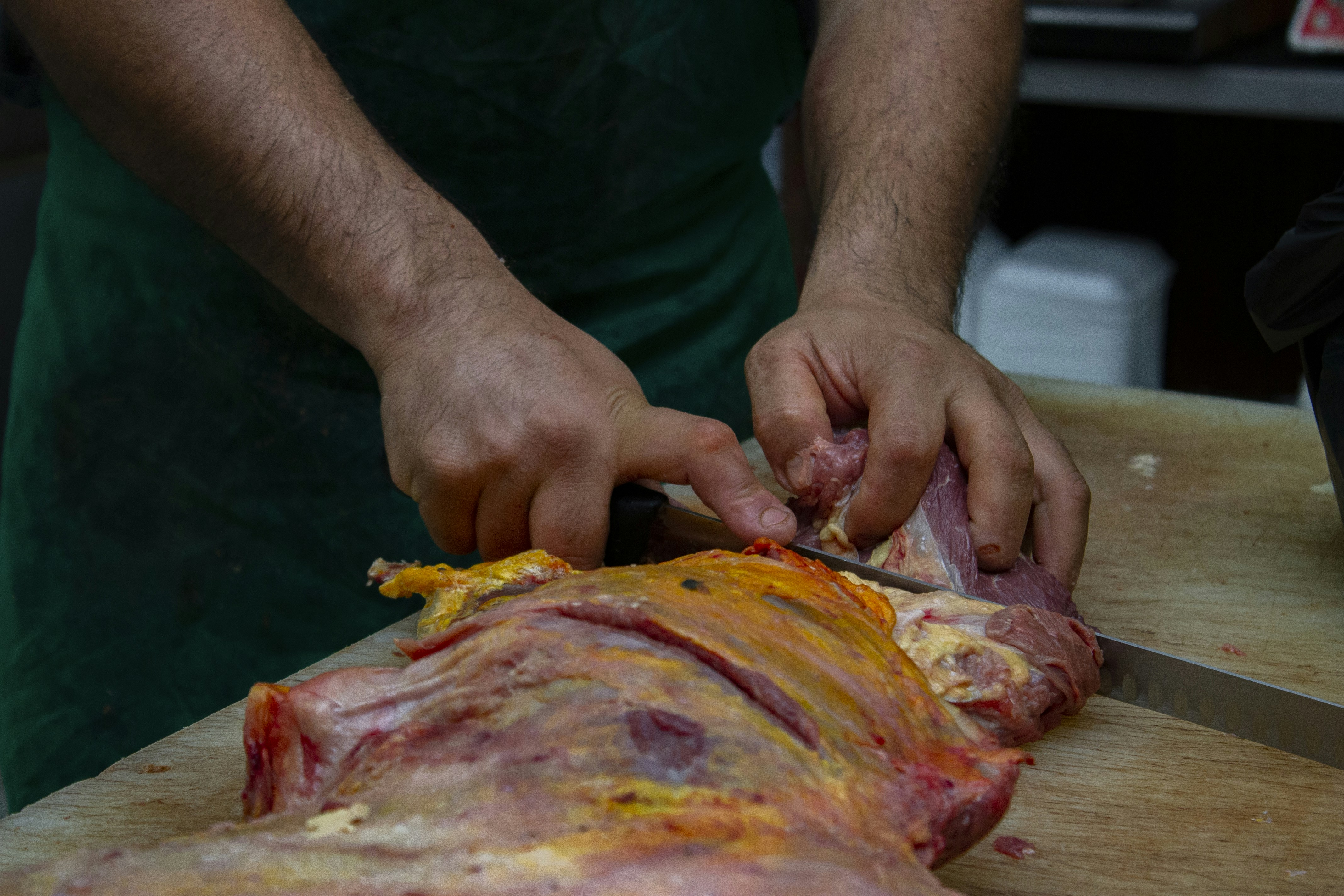 person in green shirt holding sliced pizza