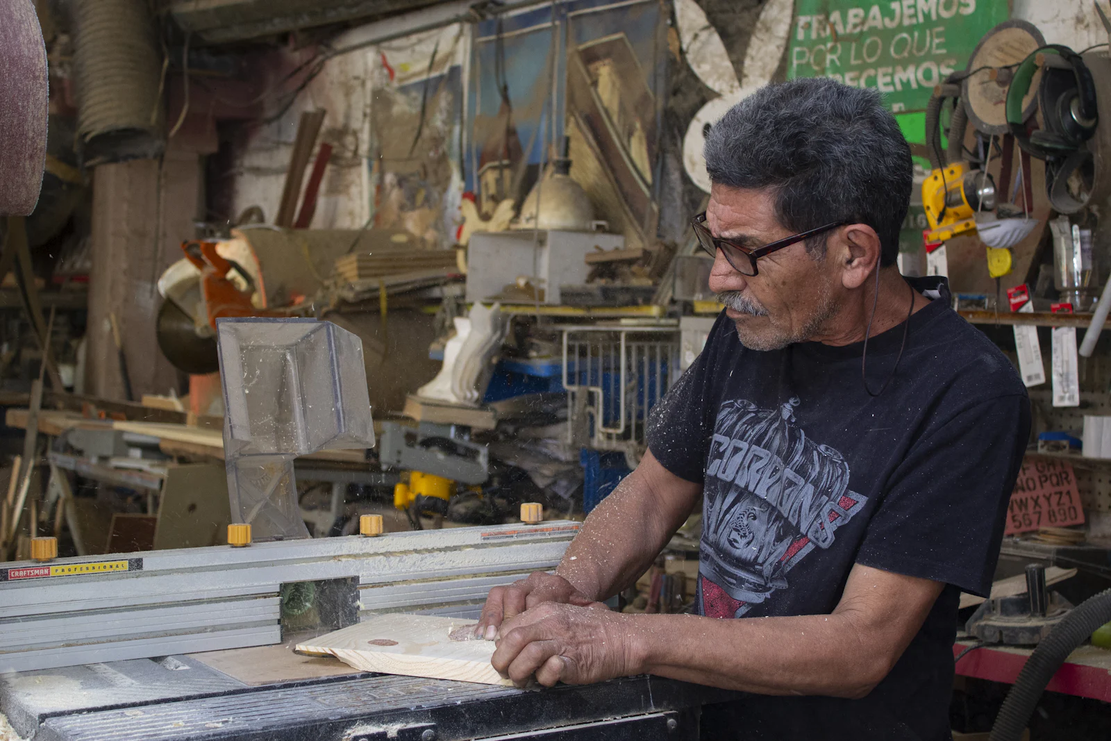 A business owner reviewing plans and paperwork on a workbench