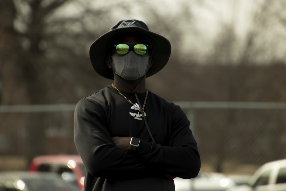 man in black jacket wearing black hat and black sunglasses