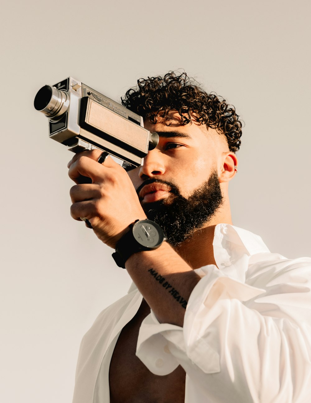 man in white dress shirt holding black and silver camera