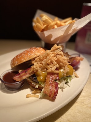 A plate featuring a burger topped with caramelized onions and a side of crisp salad.