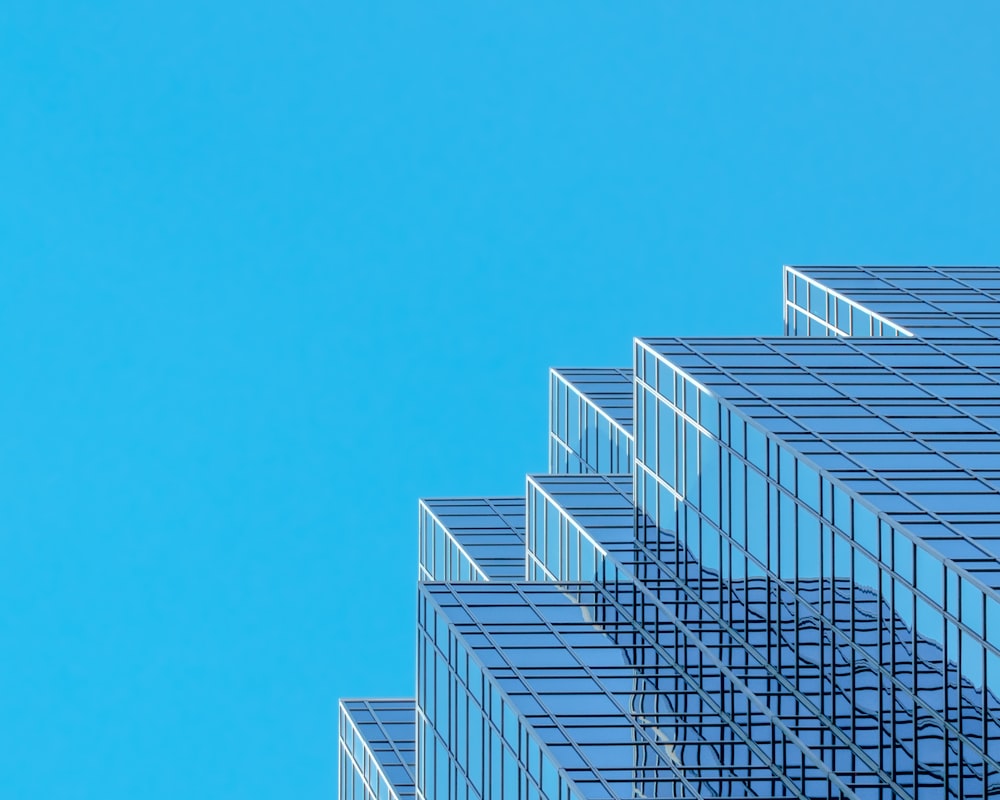 edifício de concreto branco e azul sob o céu azul durante o dia