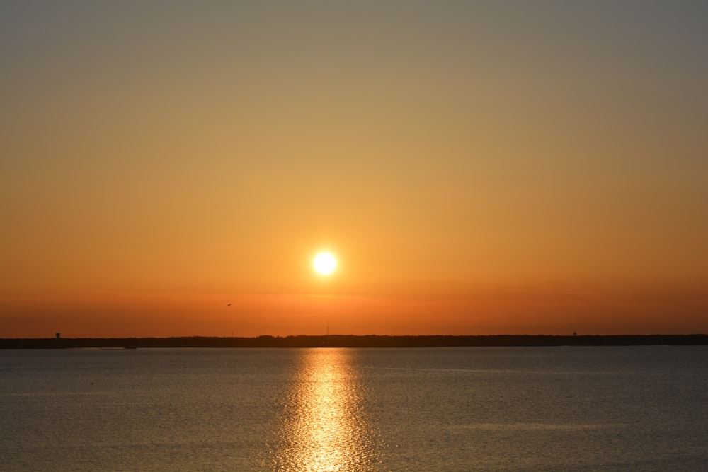 calm sea under orange sky during sunset