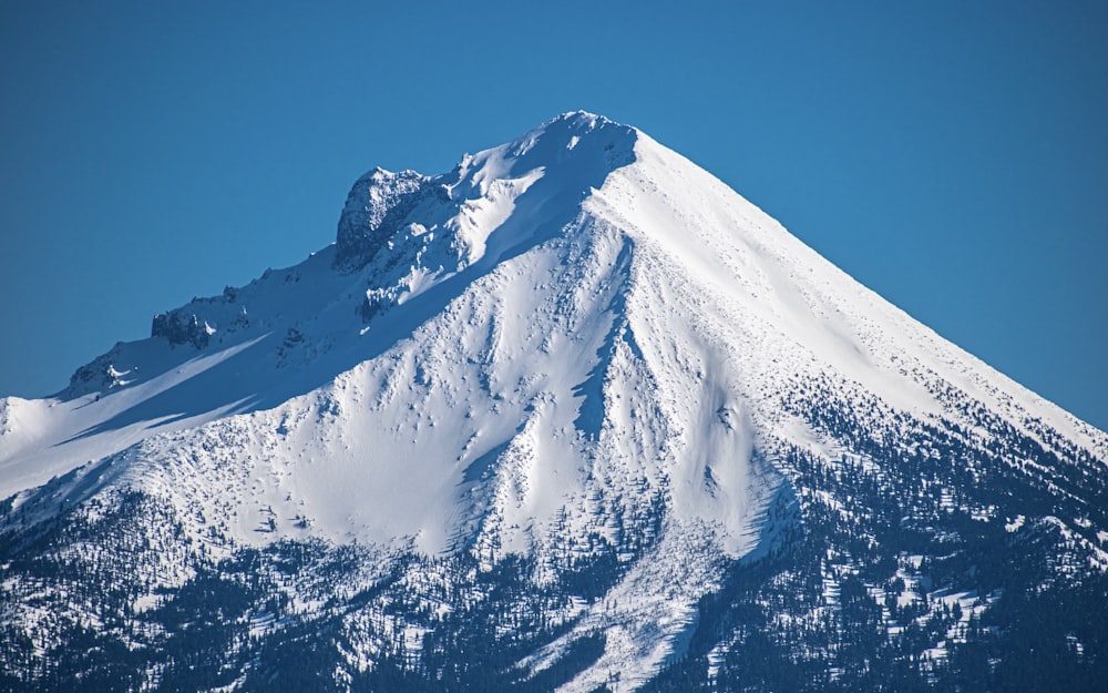 montanha coberta de neve sob o céu azul durante o dia