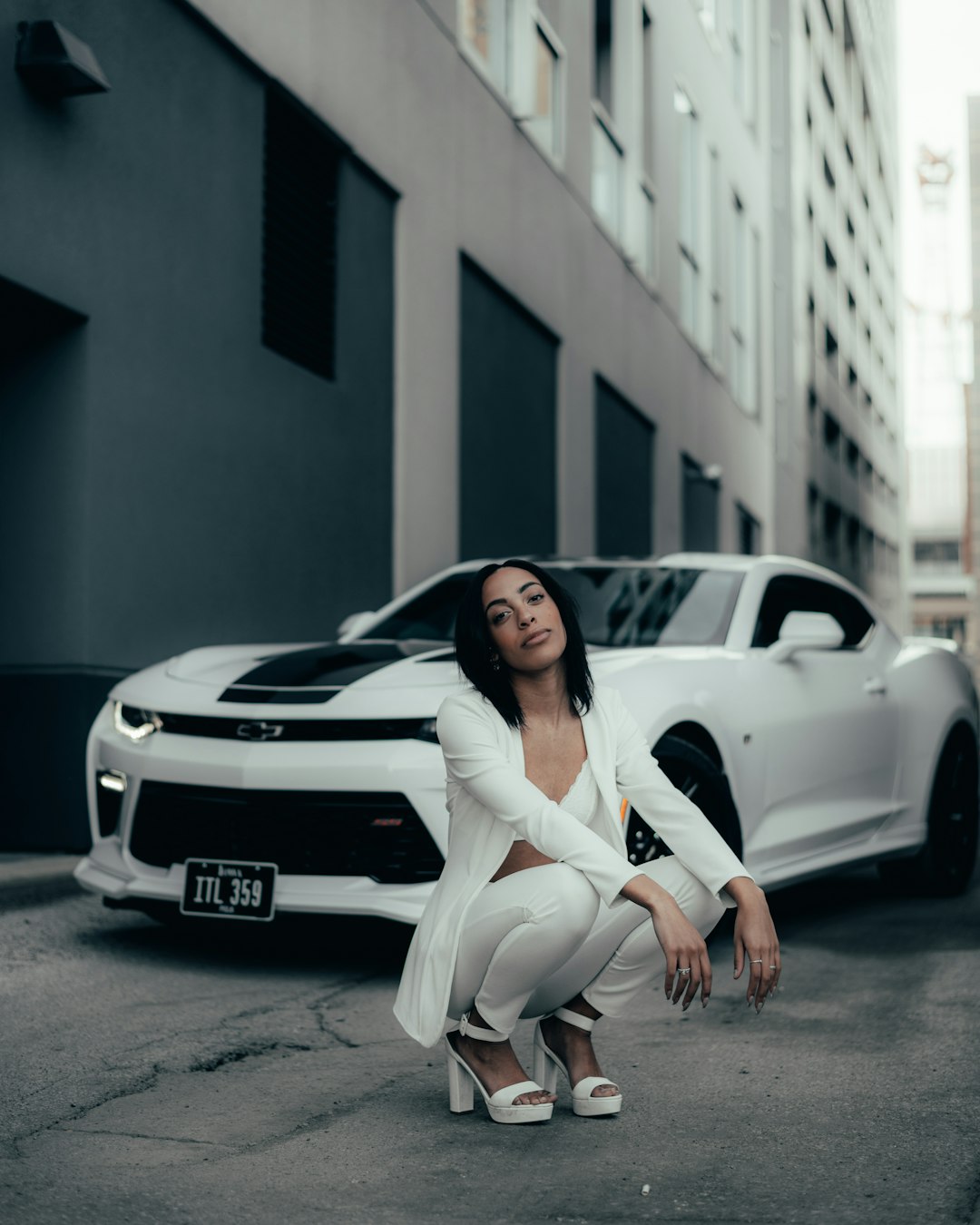 woman in white long sleeve shirt and white pants sitting on white car