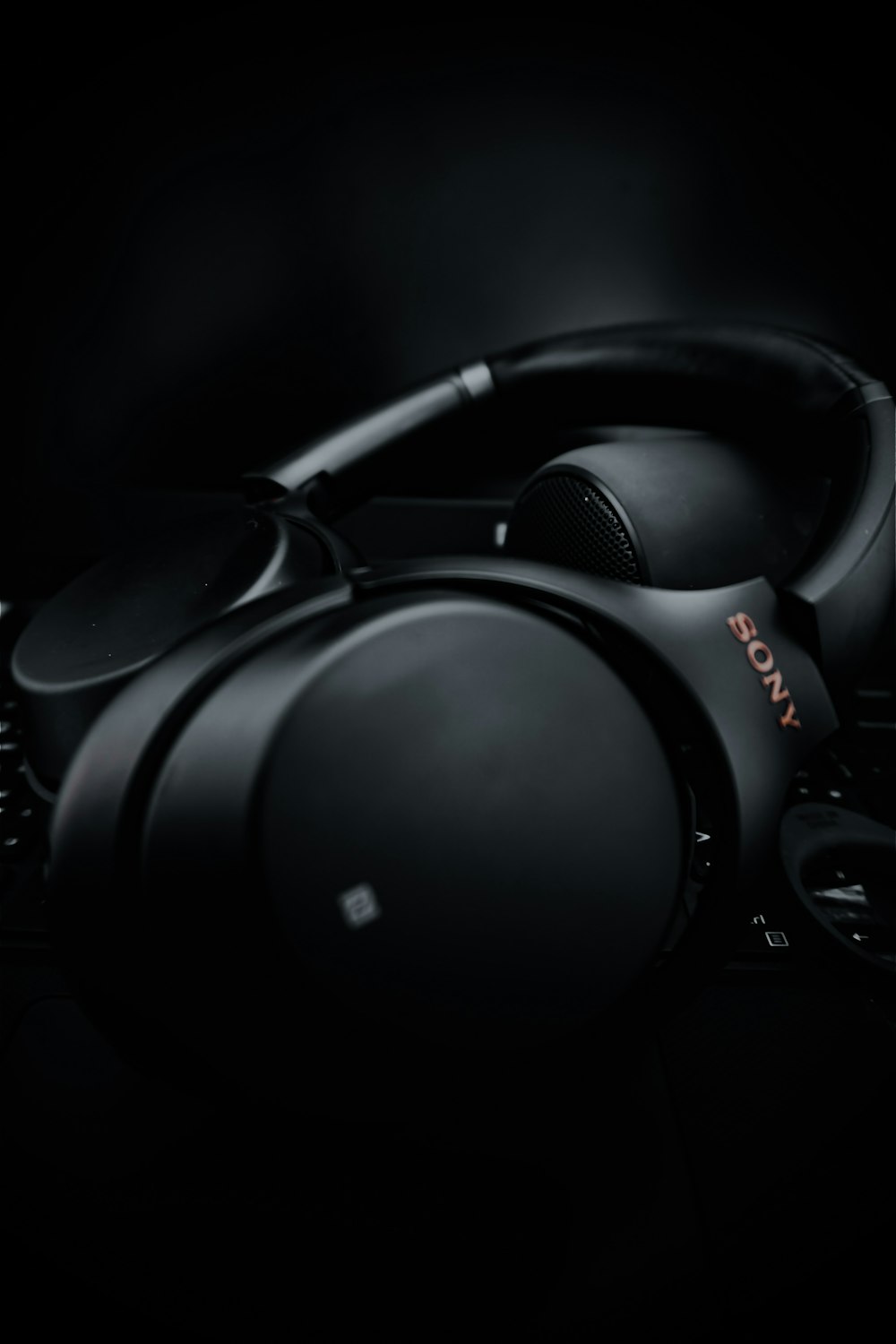 black and gray headphones on black surface